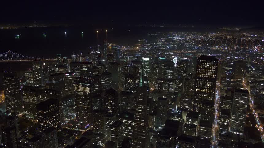 Aerial view of illuminated tall buildings next to the river at night