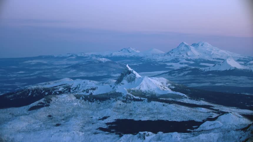 Super wide of blue hour majestic mountains of Bachelor, Jefferson, Thielsen and others at sunset in winter in the High Cascade mountains in Oregon