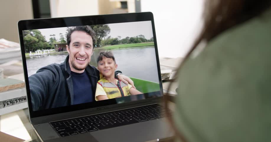 A father and son on a laptop talking to a mother