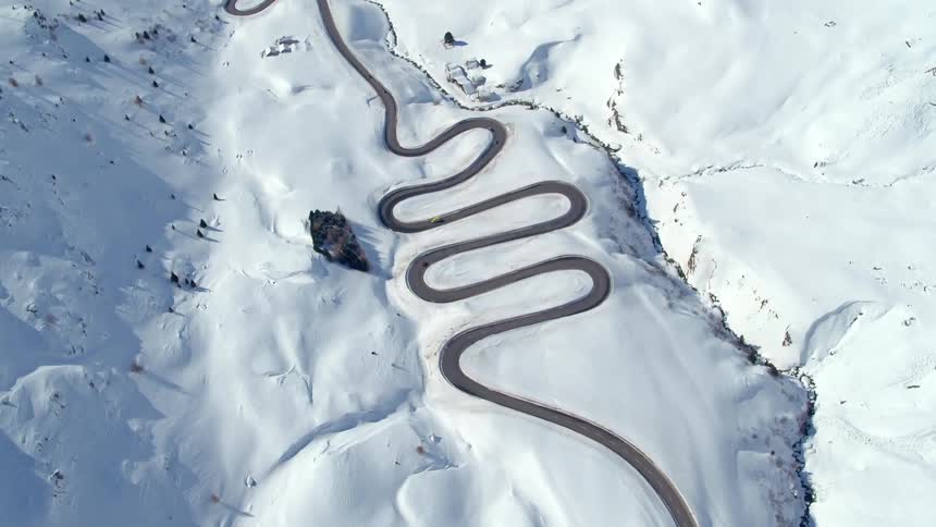 Cars travel on a winding road on a snow covered plateau
