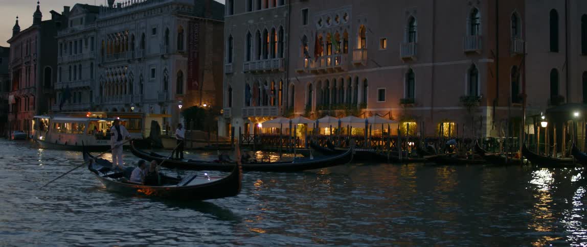 A boat is rowing in a canal at sunset