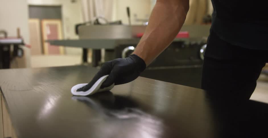 Craftsman polishing a wooden table