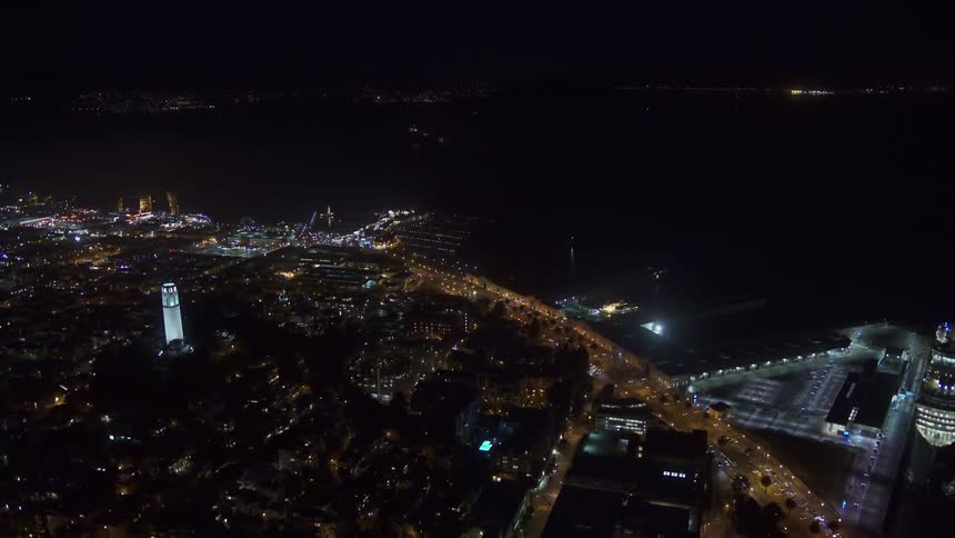 An aerial view of a city skyline on the shore with a cruise ship docked in the water