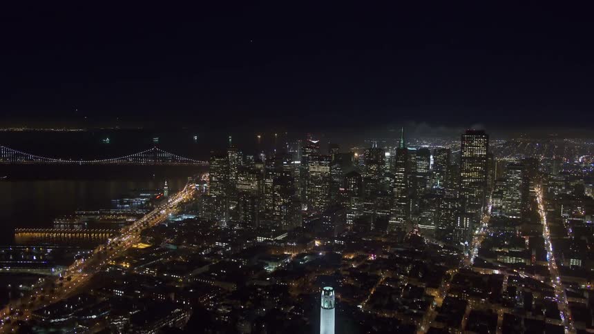 Aerial view of illuminated high rise buildings next to the river at night