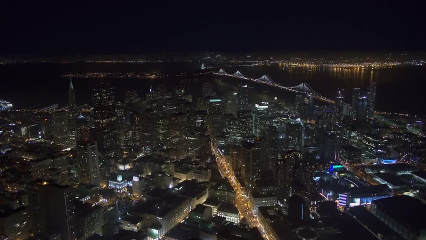 An aerial view of lights glowing in a large city at night