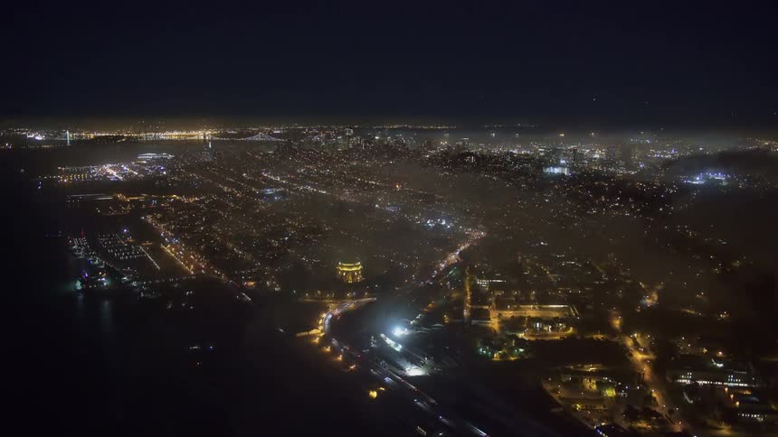 Aerial view of illuminated city with highways at night