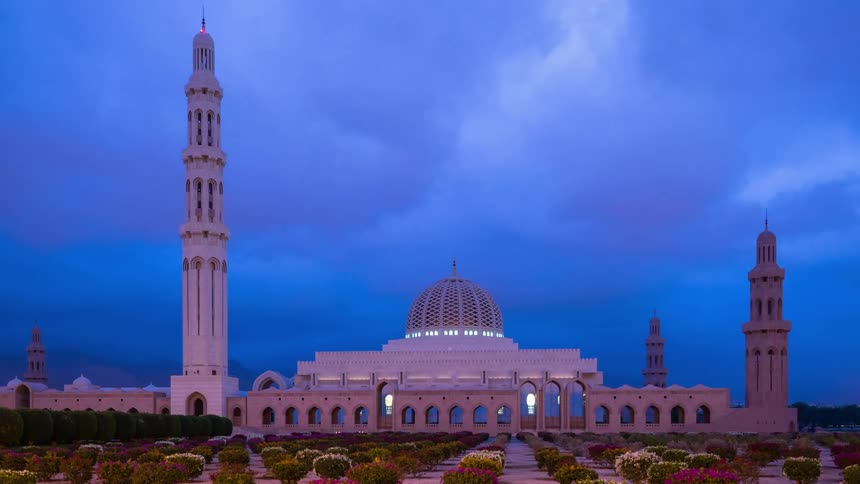 Lights lighting ornate domed building with extensive landscaped grounds turn off as sky lightens