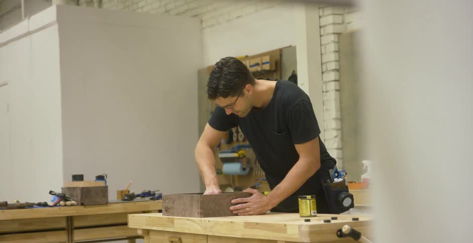 Man working on a piece of furniture in a woodshop