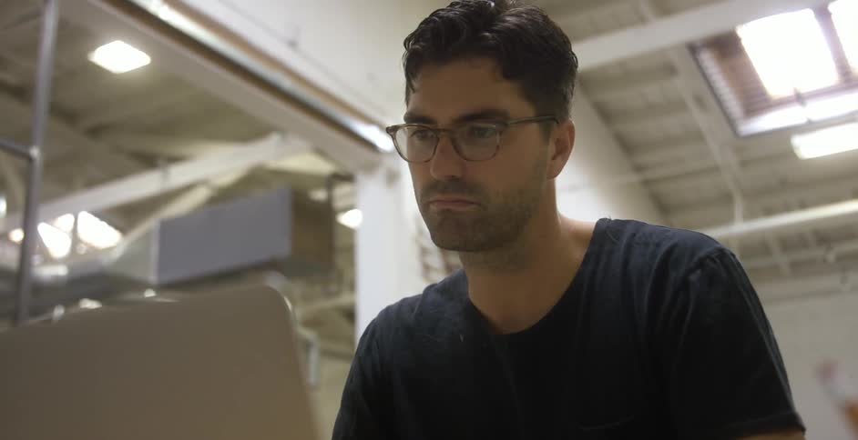 Man looking at laptop in a warehouse