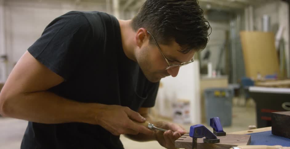 A man chiseling a piece of wood