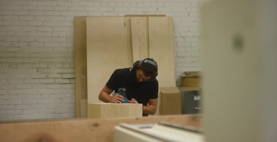 A man is cutting wood in the shop