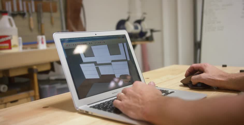 A man designing furniture on a laptop