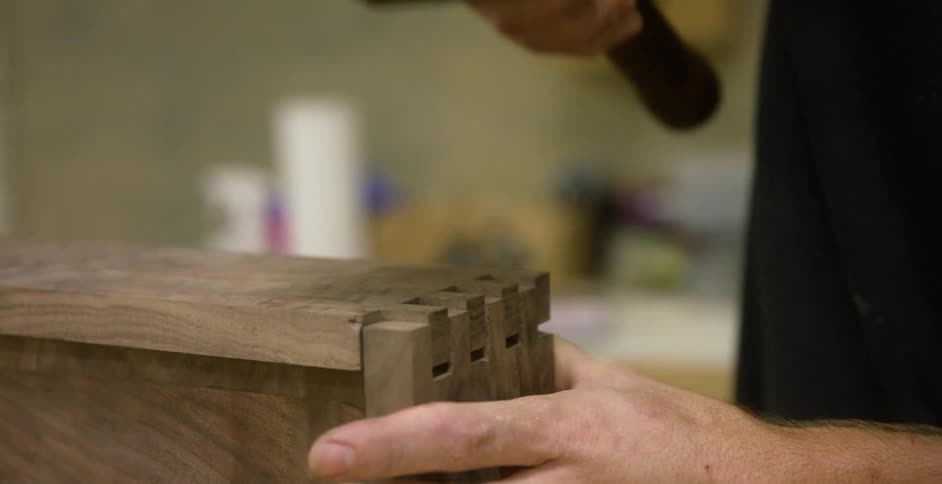 Person hammering a piece of wood into place
