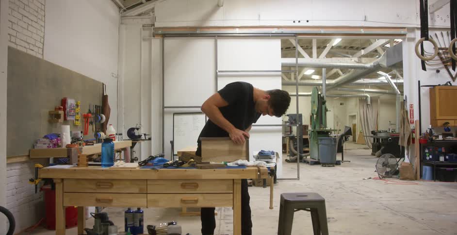 Man working at a desk in a woodworking workshop
