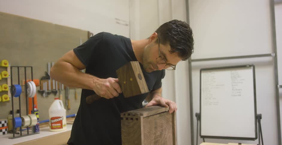 Craftsman hammering a piece of wood into place
