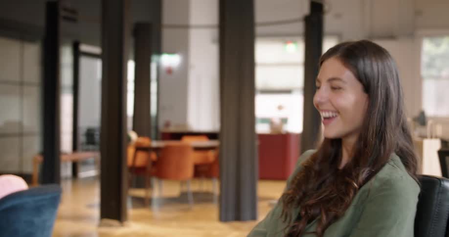 Happy young woman talks on a video call through a laptop while on the office
