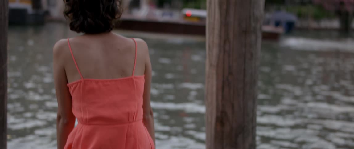 A woman is sitting by the water