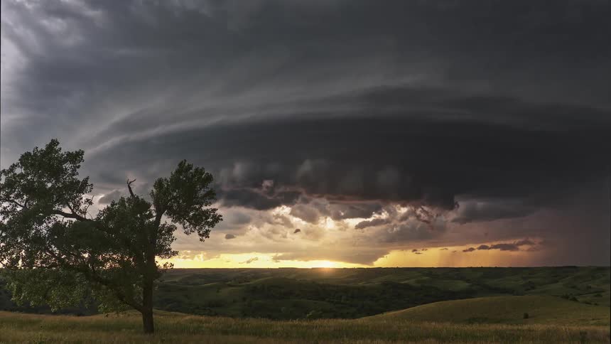 A time lapse of storm clouds moving across the sky over a field