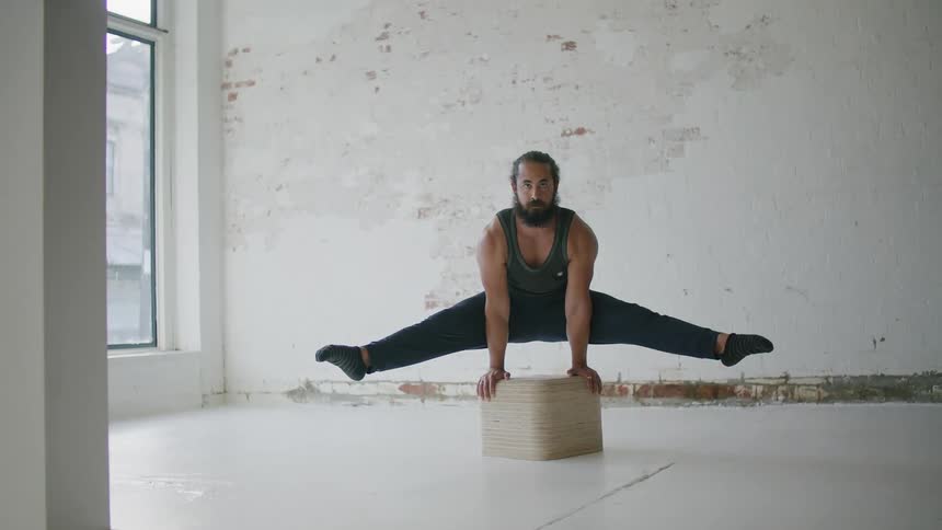 A man is doing gymnastics in the large room