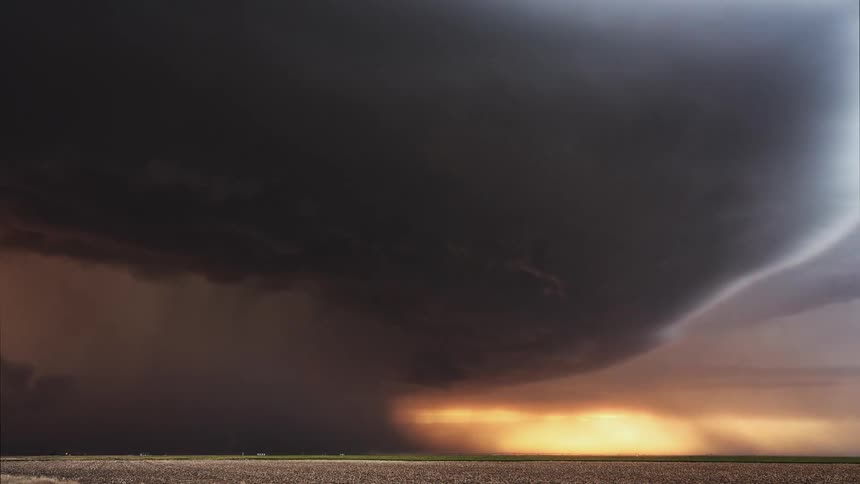 Time lapse of storm clouds and lightning over a field