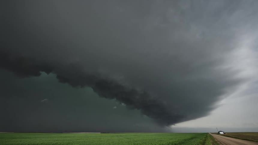 Timelapse of rain and dark storm clouds rolling over the farmland at daytime