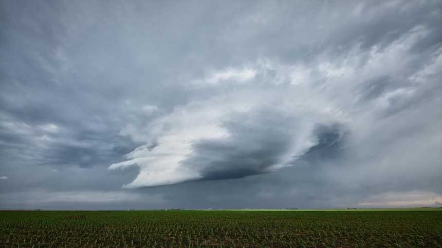 Lightning flashes as dark storm clouds move over farmland