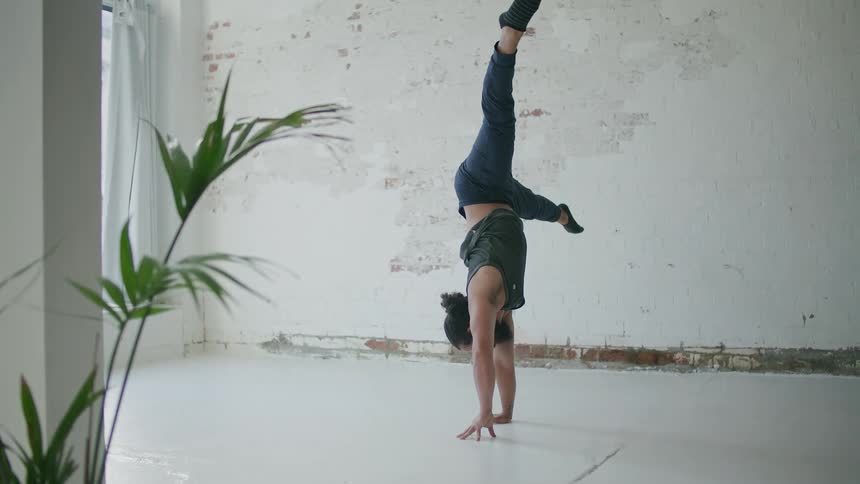 Man does two handed and one handed handstands