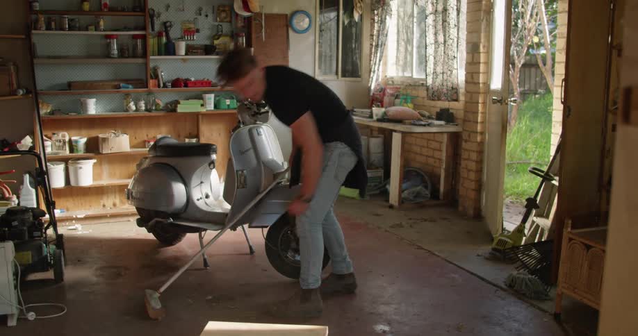 A man is cleaning up his home with a broom