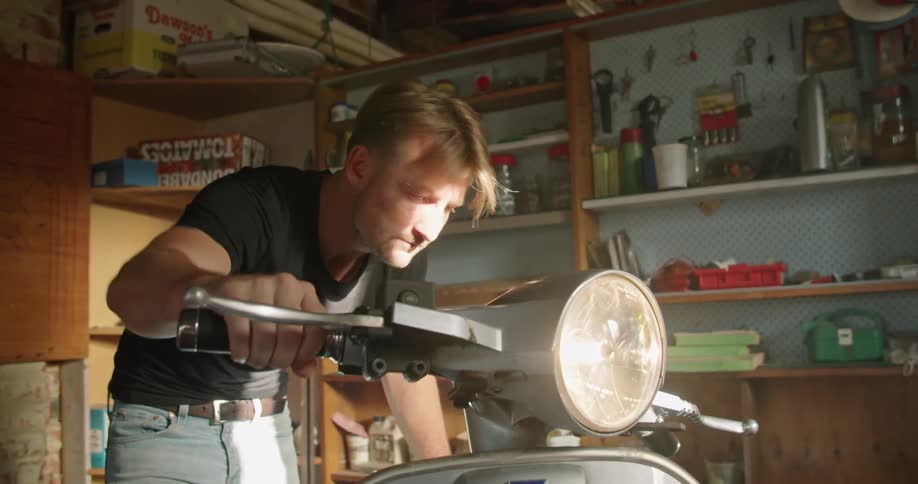 A man revs his motorcycle in his garage