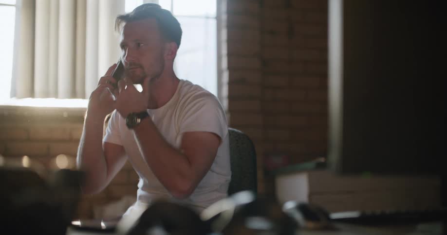 A man talking on his cell phone sitting around