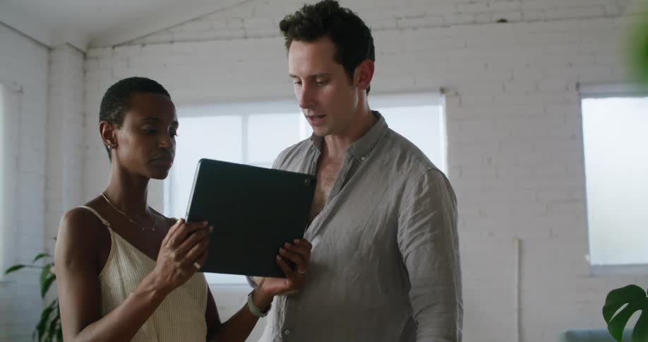 Coworkers in a meeting in the office looking at a tablet