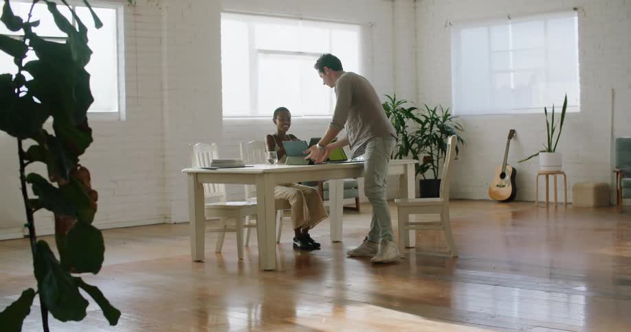 A man and woman sitting down at a desk together working