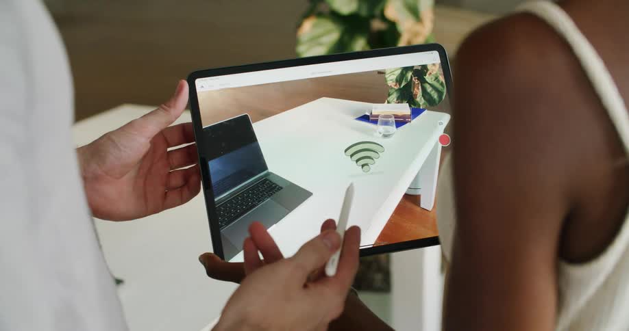 A man and woman are looking at a tablet together