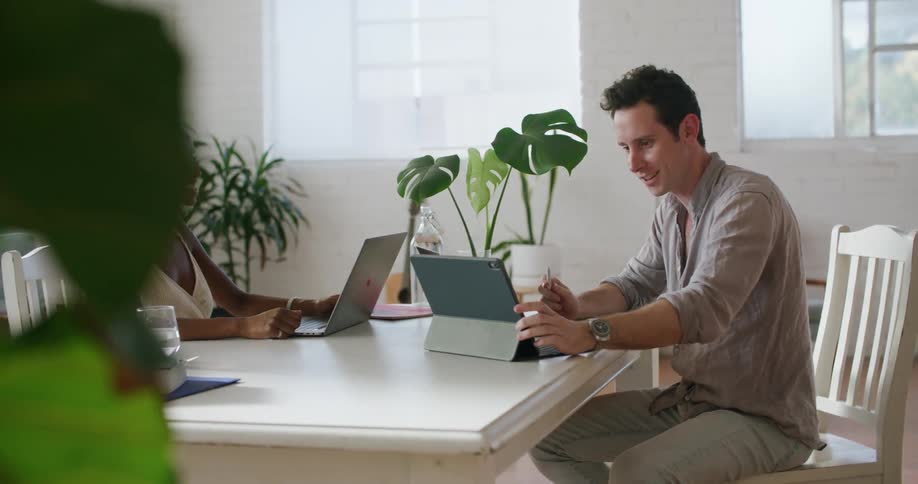 Coworkers sitting on a desk at the office celebrate an achievement