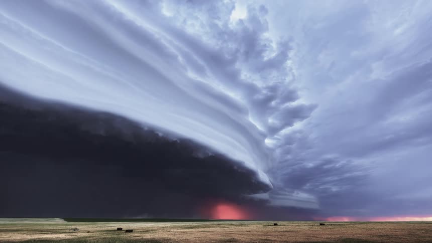 Lighting flashes in the darkness of storm clouds moving across a farmland