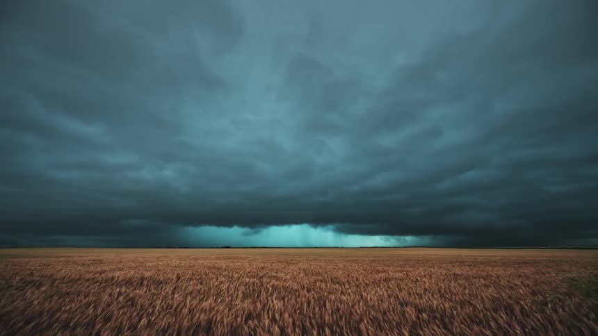 Dark storm clouds move over farmland