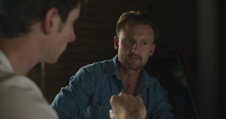 Two men on a meeting in a dimly lit office talking to each other