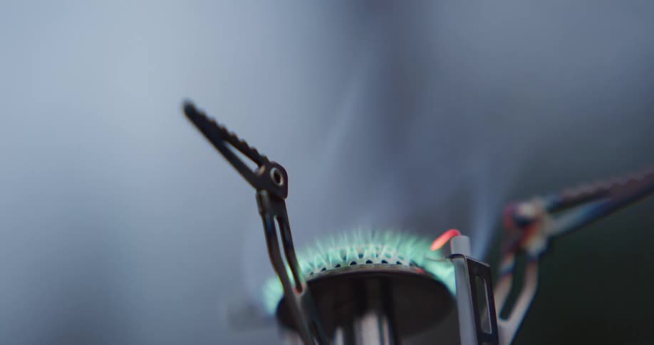 Pot is removed from small gas burner burning with blue flame