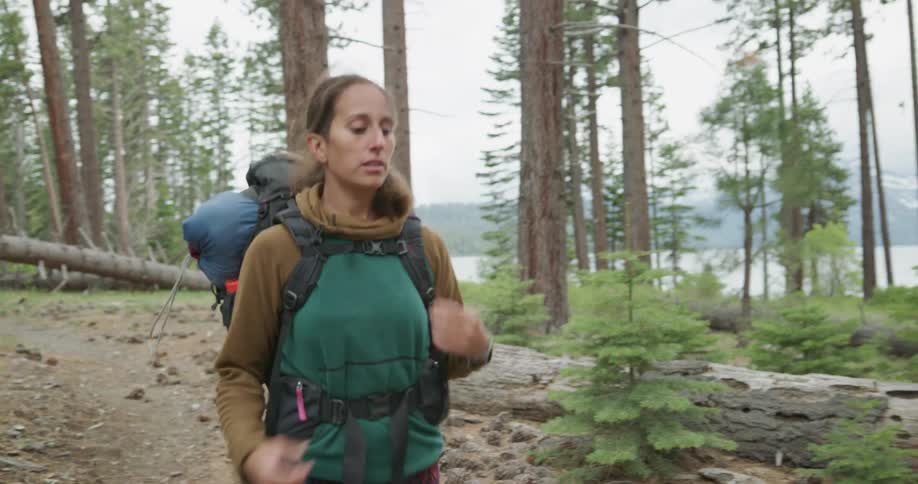 A woman hikes through a forest