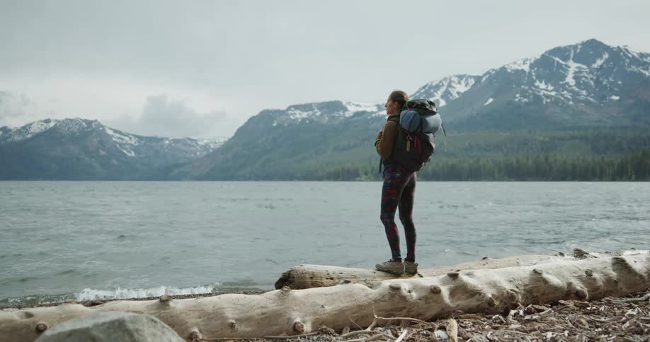 A woman standing next to a river on a hike