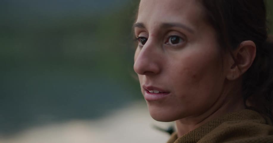 Side profile of a woman standing outside looking around at her surroundings