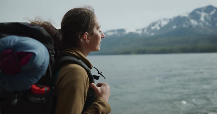 A woman is hiking by the lake