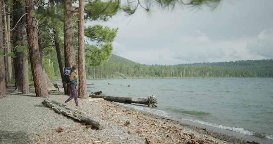 A woman that is walking near a lake