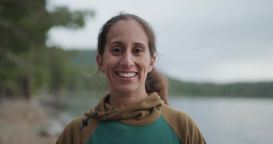 A woman that is smiling next to a river