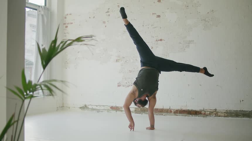 A man is balancing as he does a handstand