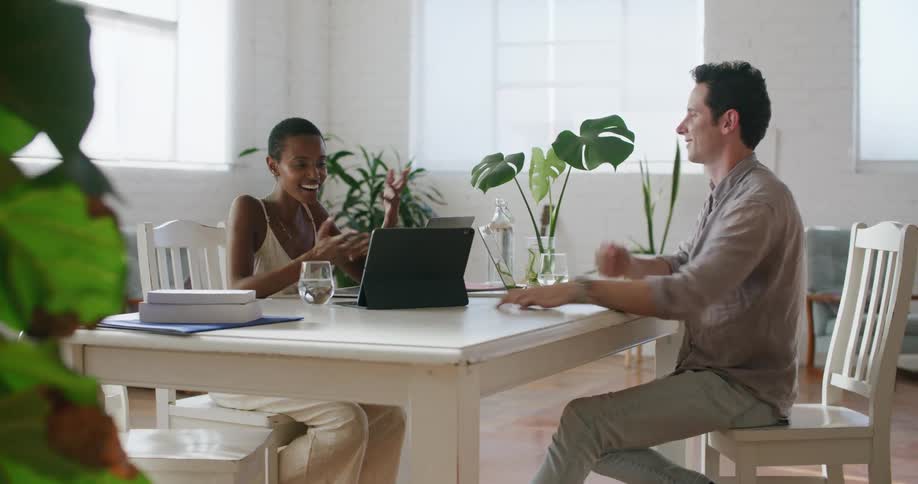 Coworkers excitedly celebrate good news while working at the office