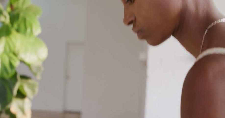 A woman in a room holding a tablet with a wall and a door in the background