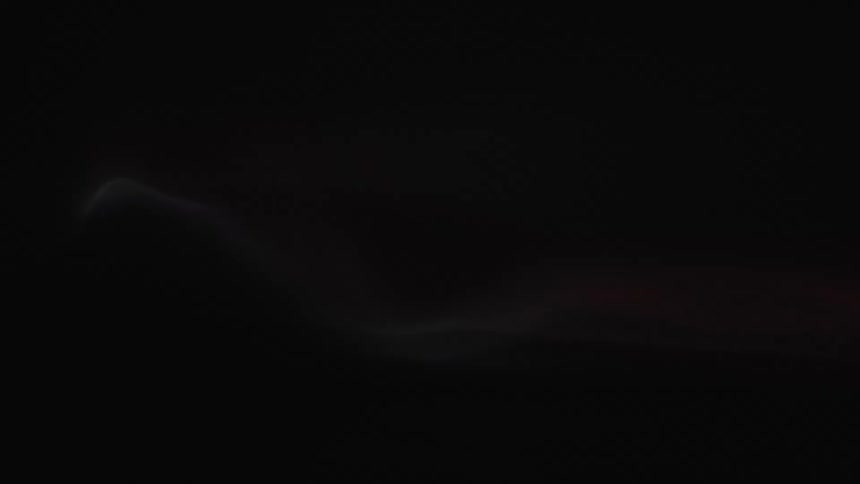 falmes and fire moves around in the dark over a black surface from side to side