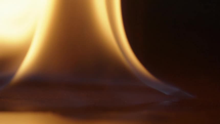 Sparks fly and flames rise as liquid on a smooth surface is set on fire