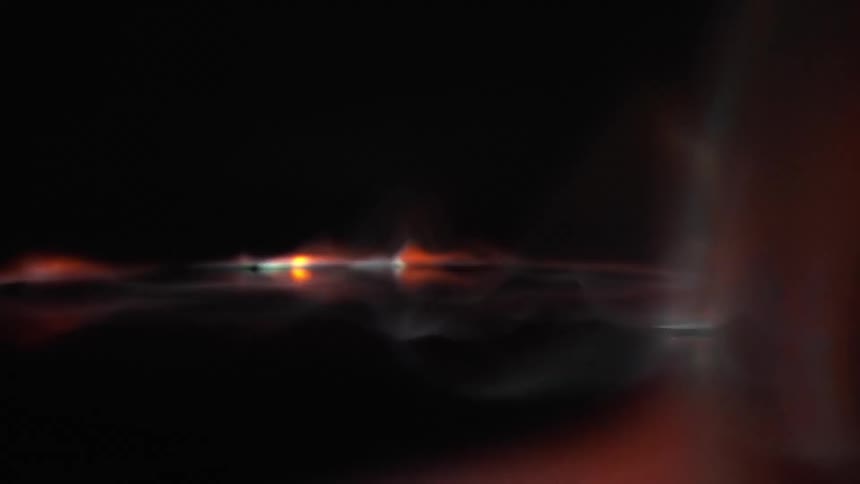 A gas flame moves across a black surface flowing orange and blue before burning out
